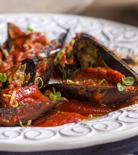 Stuffed mussels over a tomato reduction